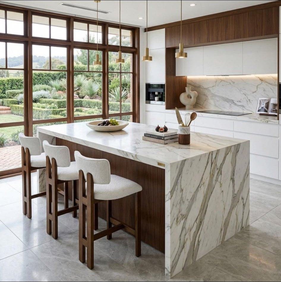 Bright kitchen with a marble waterfall island, walnut stools and garden windows