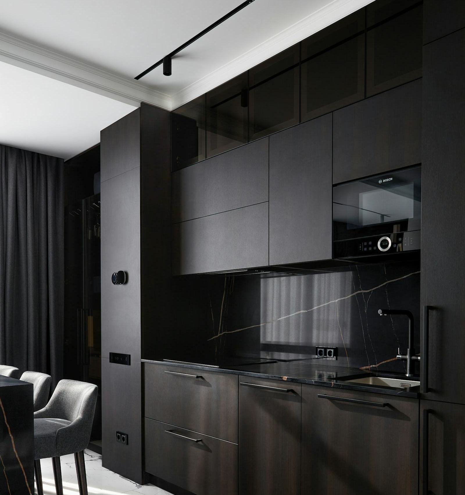 Dark kitchen with marble floor and worktops